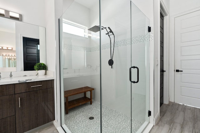 979 SW Mcdevitt Ave, Port Saint Lucie, FL 34953 - bathroom featuring a stall shower, vanity, and wood finished floors