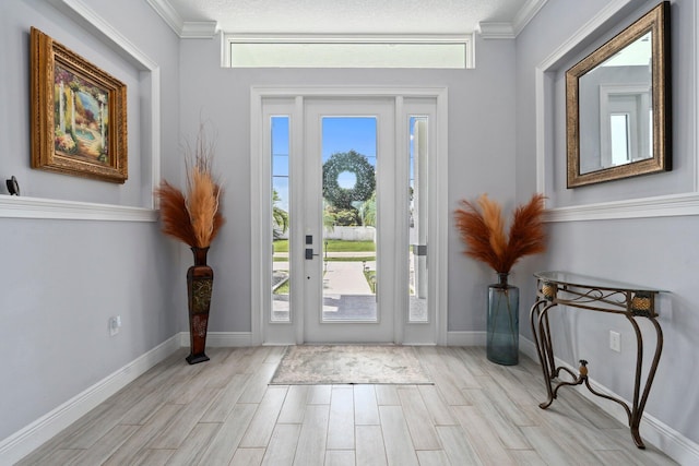 979 SW Mcdevitt Ave, Port Saint Lucie, FL 34953 - entryway featuring light wood finished floors, plenty of natural light, crown molding, and baseboards