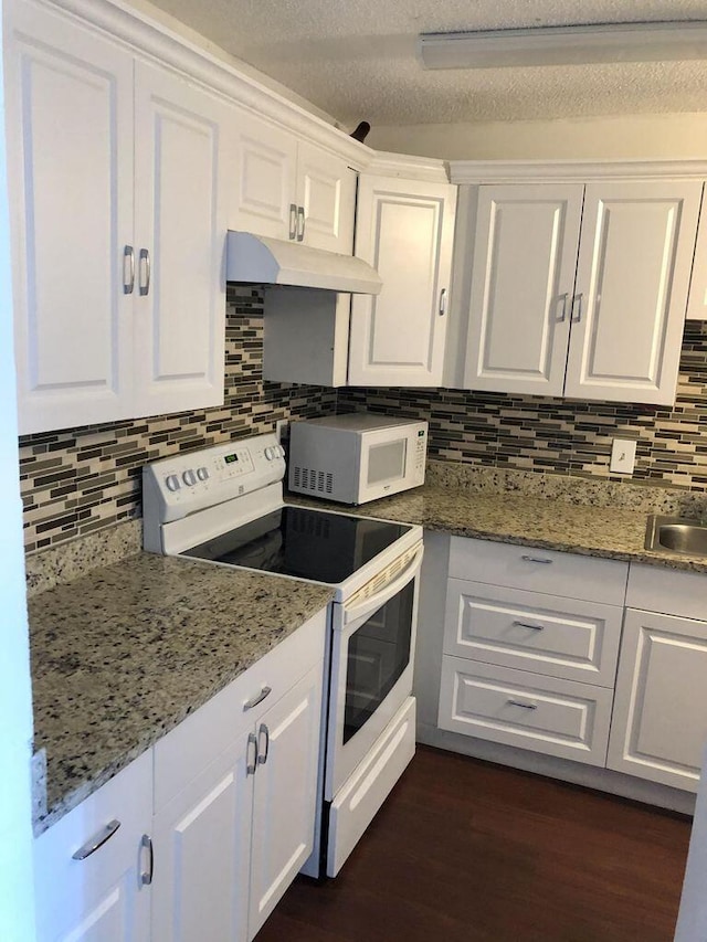13907 Via Aurora Unit A, Delray Beach, FL 33484 - kitchen featuring white appliances, under cabinet range hood, white cabinets, dark wood finished floors, and decorative backsplash