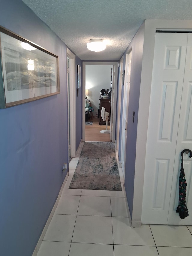 3821 Environ Blvd Unit 203, Lauderhill, FL 33319 - hallway with a textured ceiling, light tile patterned floors, and baseboards