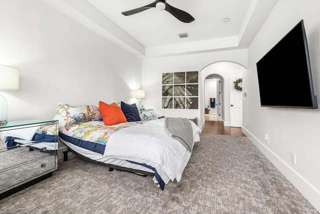 107 SE Santa Gardenia, Port Saint Lucie, FL 34984 - carpeted bedroom featuring arched walkways, a raised ceiling, a ceiling fan, and baseboards