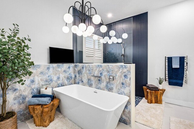 107 SE Santa Gardenia, Port Saint Lucie, FL 34984 - full bathroom featuring a chandelier, a freestanding tub, and walk in shower