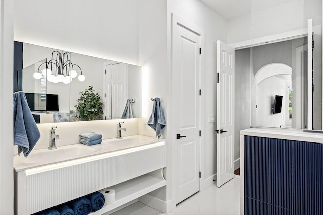 107 SE Santa Gardenia, Port Saint Lucie, FL 34984 - full bath featuring double vanity, marble look tiles, and a chandelier