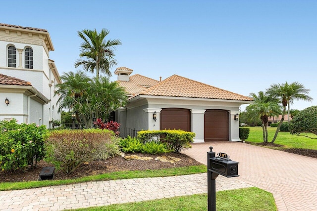 107 SE Santa Gardenia, Port Saint Lucie, FL 34984 - mediterranean / spanish-style home featuring a tile roof, an attached garage, decorative driveway, and stucco siding