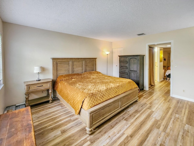 1744 Lakefront Blvd Unit C, Fort Pierce, FL 34982 - bedroom with light wood-type flooring, a textured ceiling, and baseboards