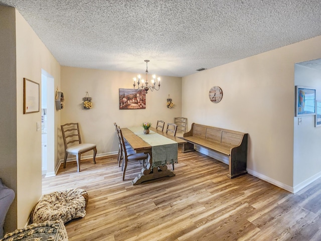 1744 Lakefront Blvd Unit C, Fort Pierce, FL 34982 - dining area featuring a chandelier, light wood-type flooring, a textured ceiling, and baseboards