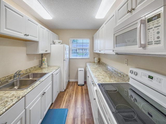 1744 Lakefront Blvd Unit C, Fort Pierce, FL 34982 - kitchen featuring white appliances, a sink, white cabinetry, light countertops, and light wood-style flooring