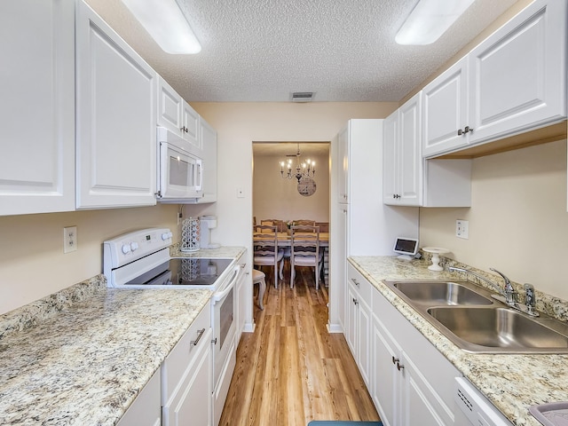 1744 Lakefront Blvd Unit C, Fort Pierce, FL 34982 - kitchen with white appliances, a sink, a chandelier, light wood-type flooring, and white cabinets