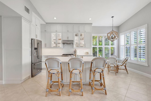 202 Isle Verde Way, Palm Beach Gardens, FL 33418 - kitchen featuring high end fridge, light countertops, under cabinet range hood, vaulted ceiling, and glass insert cabinets