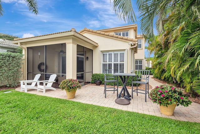 202 Isle Verde Way, Palm Beach Gardens, FL 33418 - back of house featuring a sunroom, a patio, a yard, stucco siding, and a tiled roof