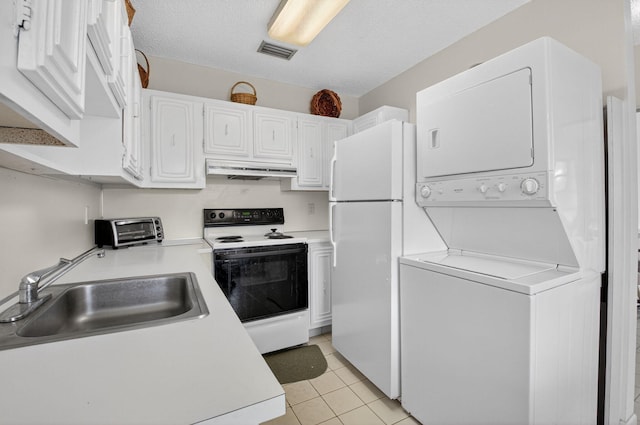 8644 Boca Dr, Boca Raton, FL 33433 - kitchen featuring white appliances, stacked washer / dryer, under cabinet range hood, light countertops, and white cabinetry
