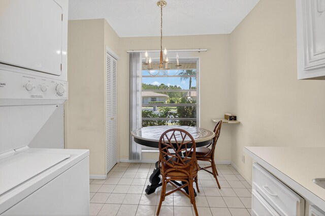 8644 Boca Dr, Boca Raton, FL 33433 - dining area featuring stacked washer / dryer, a chandelier, and light tile patterned floors