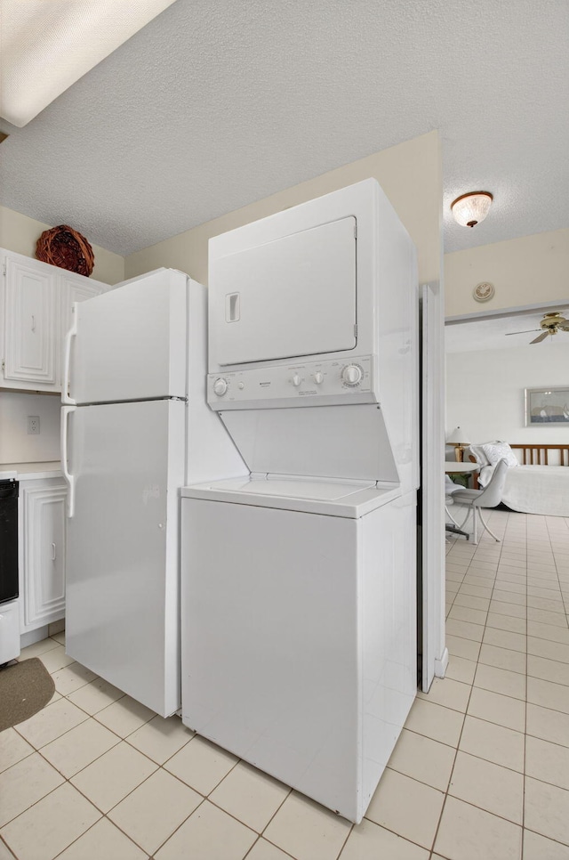 8644 Boca Dr, Boca Raton, FL 33433 - laundry room with stacked washer / drying machine, light tile patterned floors, and a textured ceiling