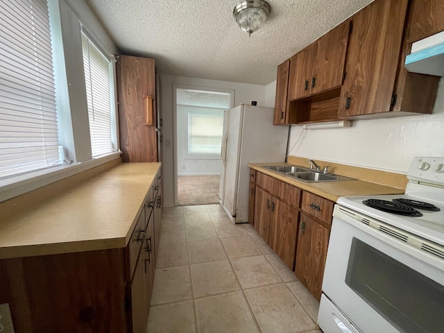2618 Nokomis Ave, West Palm Beach, FL 33409 - kitchen with white appliances, a textured ceiling, a sink, under cabinet range hood, and light countertops