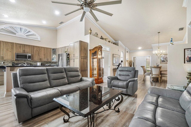 7465 Rockbridge Cir, Lake Worth, FL 33467 - living room with a ceiling fan, a chandelier, high vaulted ceiling, ornamental molding, and light wood-type flooring
