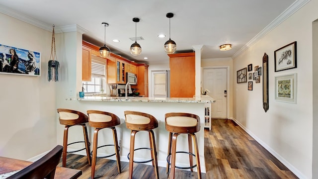 3001 W Linton Blvd Unit 204C, Delray Beach, FL 33445 - kitchen featuring stainless steel microwave, a breakfast bar, dark wood-style floors, ornamental molding, and glass insert cabinets