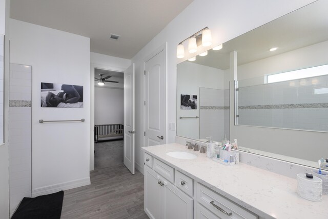 10299 SW Captiva Dr, Port Saint Lucie, FL 34987 - full bathroom with vanity, wood finished floors, a ceiling fan, walk in shower, and baseboards