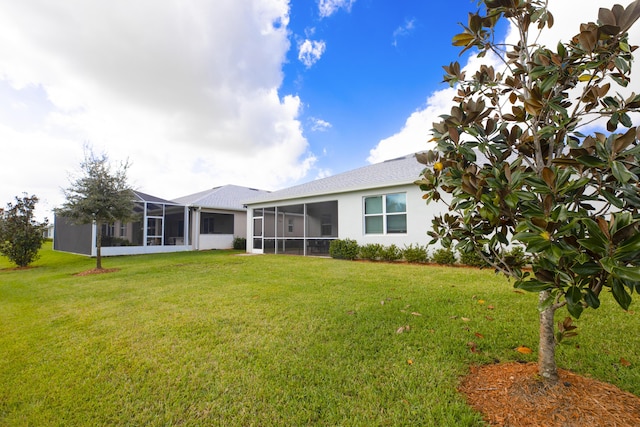 10299 SW Captiva Dr, Port Saint Lucie, FL 34987 - back of property with a lawn, stucco siding, and a sunroom