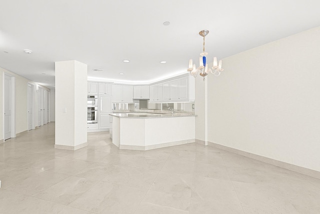 800 Ocean Dr Unit 204, Juno Beach, FL 33408 - kitchen featuring a chandelier, white cabinetry, a peninsula, baseboards, and recessed lighting