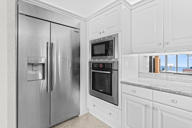 800 Ocean Dr Unit 204, Juno Beach, FL 33408 - kitchen with built in appliances, light stone counters, and white cabinets