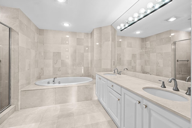 800 Ocean Dr Unit 204, Juno Beach, FL 33408 - full bath featuring a garden tub, double vanity, tile walls, a stall shower, and tile patterned floors