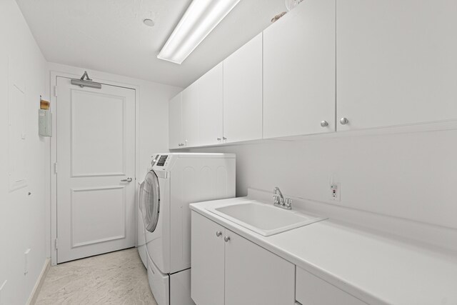 800 Ocean Dr Unit 204, Juno Beach, FL 33408 - laundry room with cabinet space, washer and dryer, light marble finish flooring, and baseboards