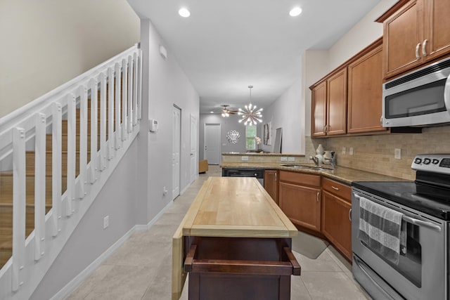 474 Francesca Ridge Rd, Boynton Beach, FL 33435 - kitchen with appliances with stainless steel finishes, tasteful backsplash, brown cabinets, a sink, and light tile patterned floors