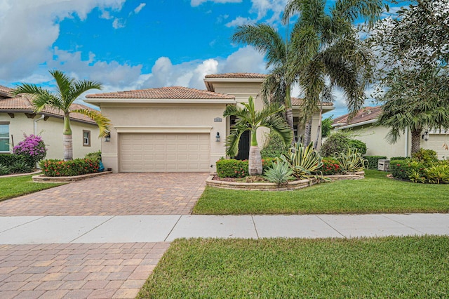 18006 SW Cosenza Way, Port Saint Lucie, FL 34987 - mediterranean / spanish-style house with a garage, a tile roof, decorative driveway, stucco siding, and a front yard