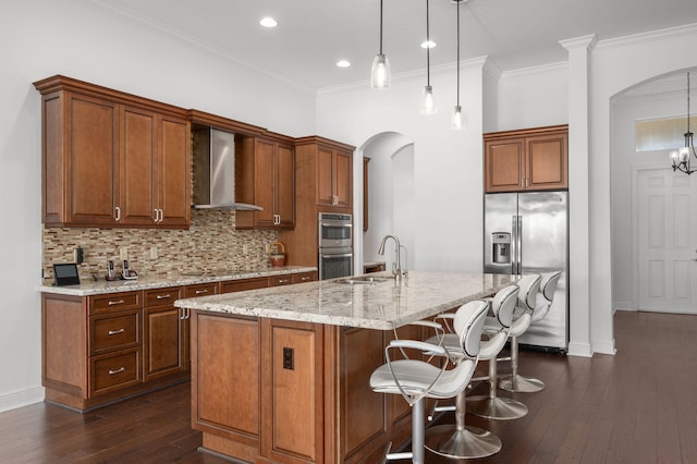 18006 SW Cosenza Way, Port Saint Lucie, FL 34987 - kitchen with wall chimney range hood, appliances with stainless steel finishes, arched walkways, a sink, and dark wood finished floors