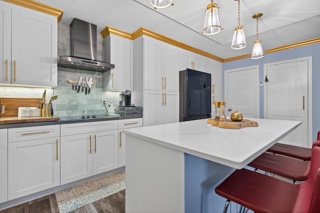 1508 15th Ter, Palm Beach Gardens, FL 33418 - kitchen featuring wall chimney range hood, fridge, backsplash, a kitchen breakfast bar, and white cabinetry