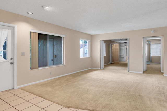 531 Shady Pine Way Unit A 2, Greenacres, FL 33415 - unfurnished living room featuring carpet floors, baseboards, a textured ceiling, tile patterned floors, and recessed lighting