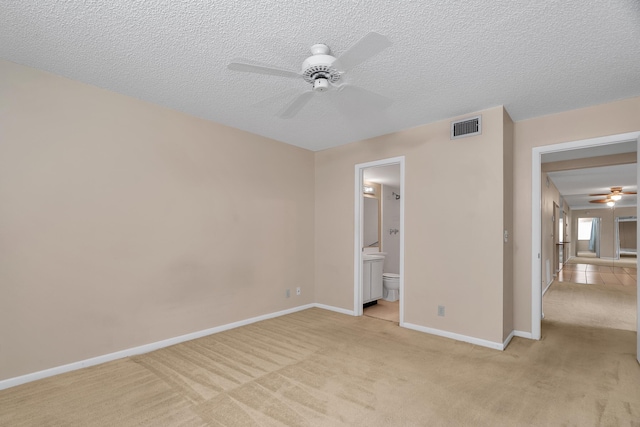531 Shady Pine Way Unit A 2, Greenacres, FL 33415 - unfurnished bedroom with light carpet, a textured ceiling, baseboards, connected bathroom, and a ceiling fan
