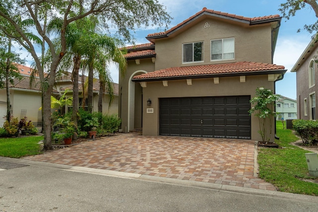 1026 Center Stone Ln, Riviera Beach, FL 33404 - mediterranean / spanish home with a garage, a tiled roof, stucco siding, and decorative driveway