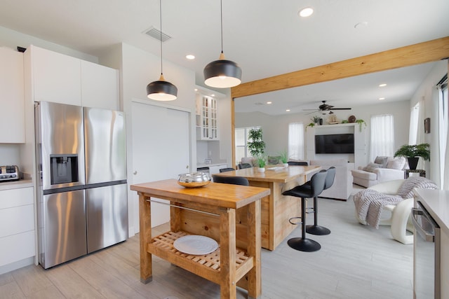 1026 Center Stone Ln, Riviera Beach, FL 33404 - kitchen with appliances with stainless steel finishes, white cabinetry, light wood-style floors, recessed lighting, and pendant lighting