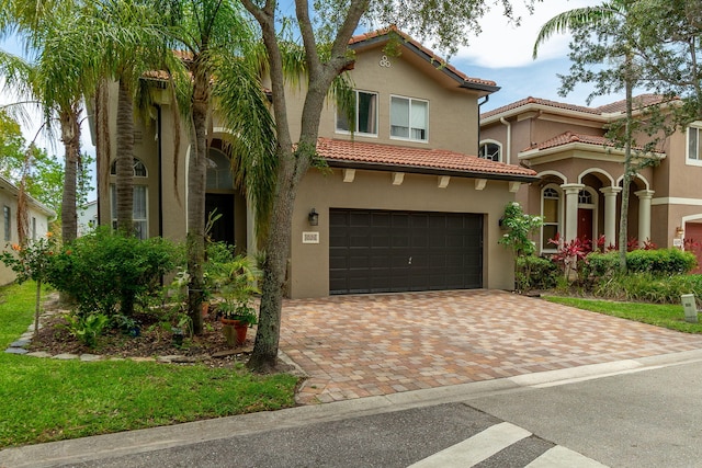 1026 Center Stone Ln, Riviera Beach, FL 33404 - mediterranean / spanish-style home with a garage, a tiled roof, stucco siding, and decorative driveway
