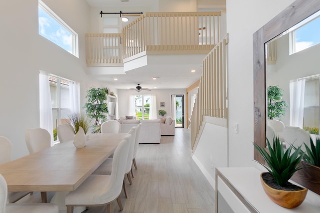 1026 Center Stone Ln, Riviera Beach, FL 33404 - dining space featuring a towering ceiling, light wood-type flooring, and a ceiling fan