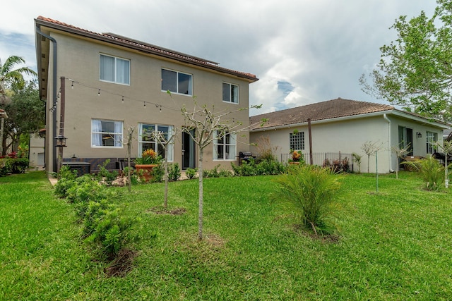 1026 Center Stone Ln, Riviera Beach, FL 33404 - rear view of house with stucco siding, a tiled roof, and a yard