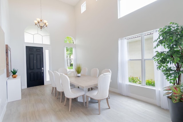 1026 Center Stone Ln, Riviera Beach, FL 33404 - dining space featuring a chandelier, a high ceiling, and light wood finished floors