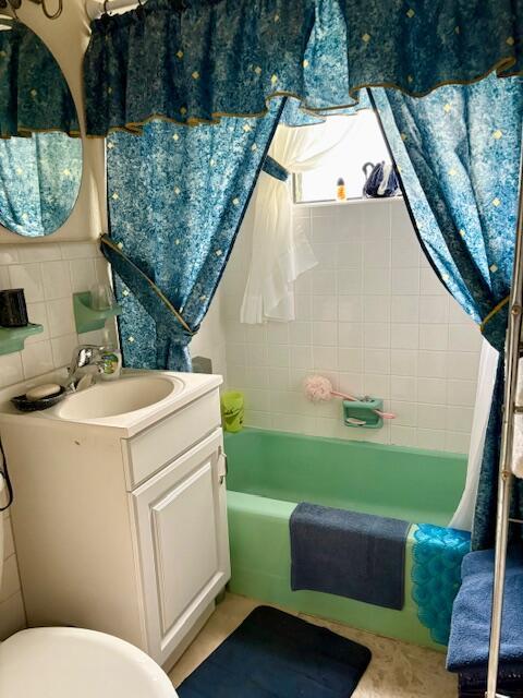 729 W Kalmia Dr, Lake Park, FL 33403 - bathroom featuring vanity, bathing tub / shower combination, and toilet