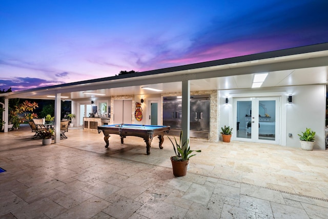 936 Upland Rd, West Palm Beach, FL 33401 - patio terrace at dusk featuring french doors, a patio, and outdoor dining space