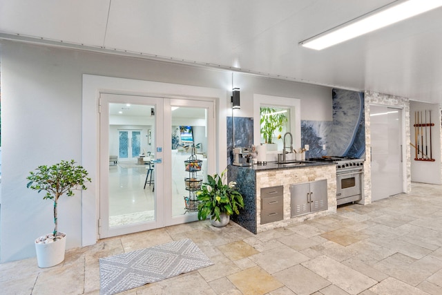 936 Upland Rd, West Palm Beach, FL 33401 - kitchen with designer range, a sink, and stone tile floors