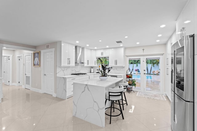 936 Upland Rd, West Palm Beach, FL 33401 - kitchen with smart refrigerator, wall chimney exhaust hood, gas stovetop, modern cabinets, and white cabinetry