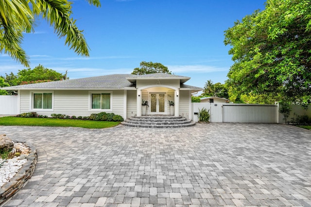 936 Upland Rd, West Palm Beach, FL 33401 - view of front of property featuring decorative driveway, french doors, and a gate