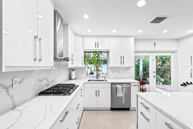 936 Upland Rd, West Palm Beach, FL 33401 - kitchen with appliances with stainless steel finishes, a sink, white cabinets, modern cabinets, and wall chimney range hood