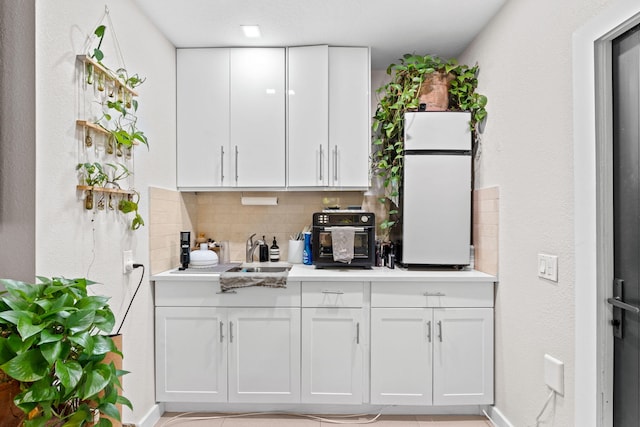 936 Upland Rd, West Palm Beach, FL 33401 - kitchen with white cabinets, decorative backsplash, a sink, and light countertops