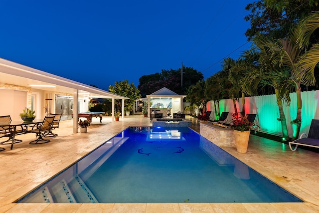 936 Upland Rd, West Palm Beach, FL 33401 - pool at night featuring an outdoor pool, a gazebo, and a patio area
