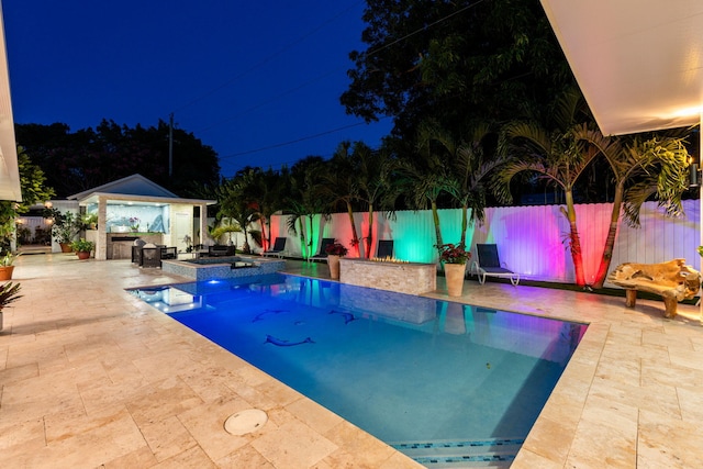 936 Upland Rd, West Palm Beach, FL 33401 - pool at night with a patio, a fenced backyard, an outbuilding, and a pool with connected hot tub