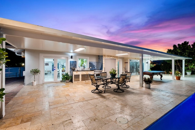 936 Upland Rd, West Palm Beach, FL 33401 - patio terrace at dusk featuring french doors, a patio, and outdoor dining space