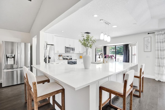 3985 NW 73rd Way, Coral Springs, FL 33065 - kitchen featuring stainless steel appliances, dark wood-style floors, white cabinets, tasteful backsplash, and light countertops