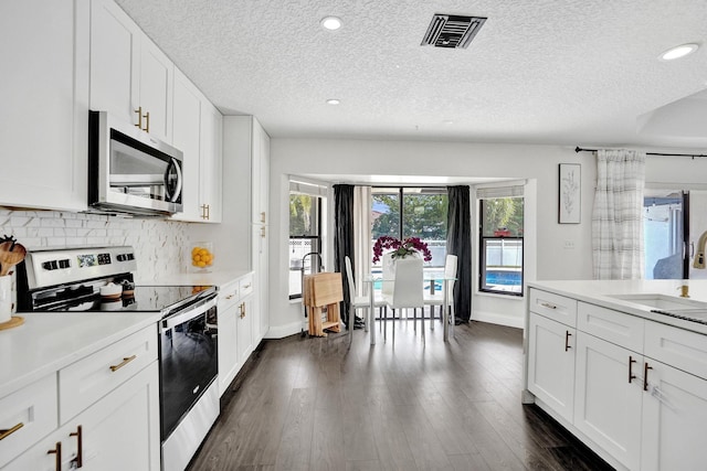 3985 NW 73rd Way, Coral Springs, FL 33065 - kitchen featuring appliances with stainless steel finishes, a textured ceiling, light countertops, backsplash, and baseboards